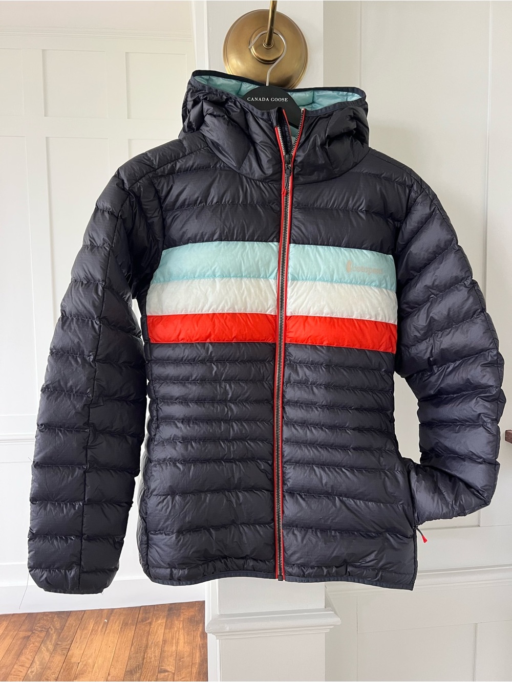 Cotopaxi Womenβs Hooded Puffer Jacket with Stripe Detail Navy Large